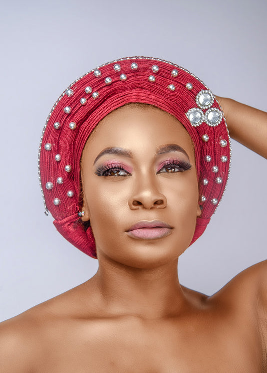 a woman wearing a red turban with pearls on it