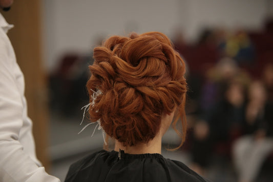 a woman with red hair is getting her hair done