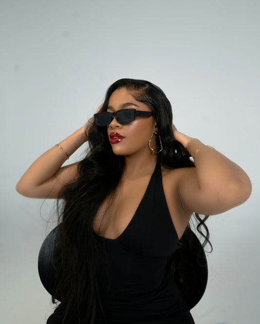 A woman wearing a black dress and sunglasses