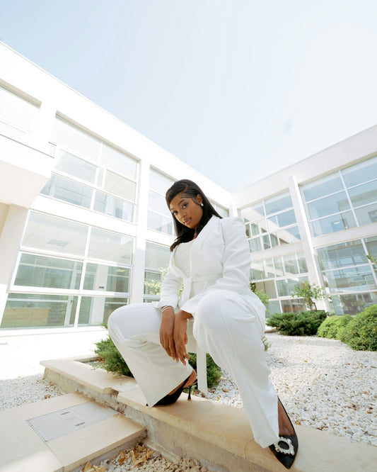 A woman in a white suit sitting on a step