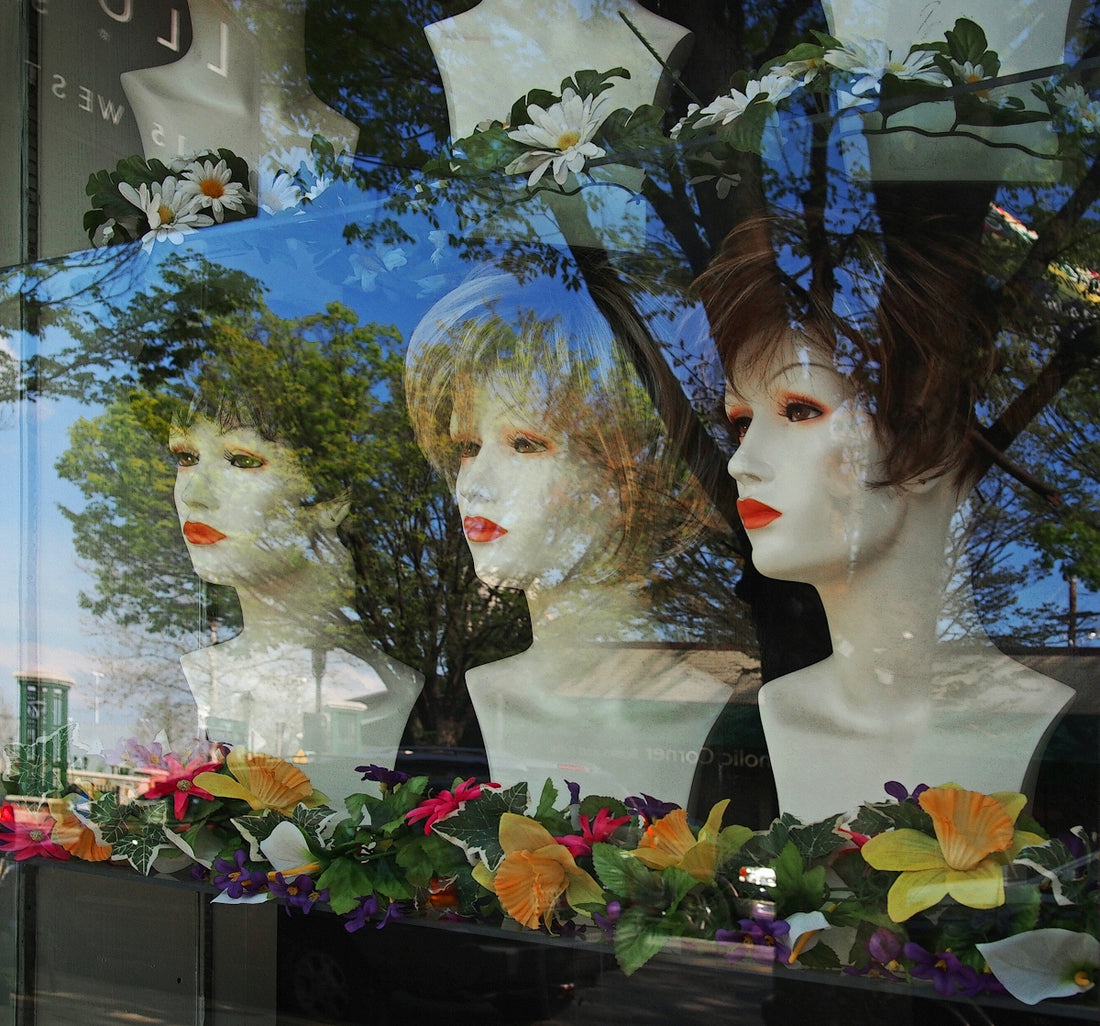 A window display of mannequins and flowers