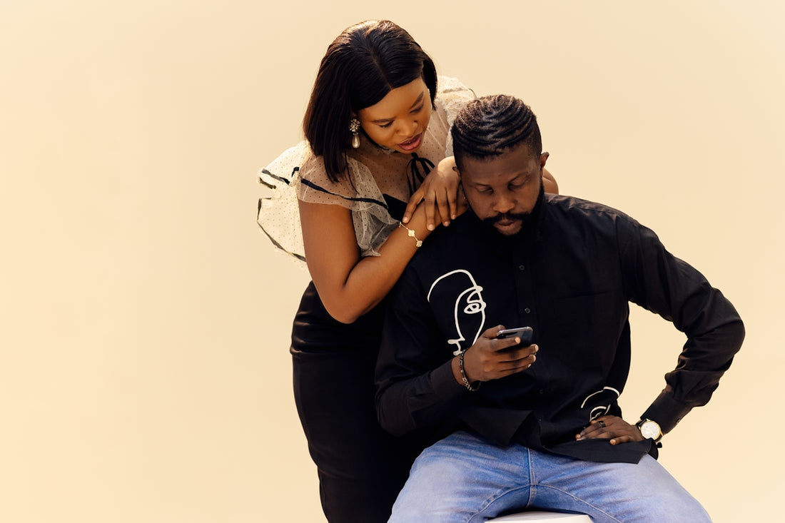 A man sitting on a woman's lap with a cell phone