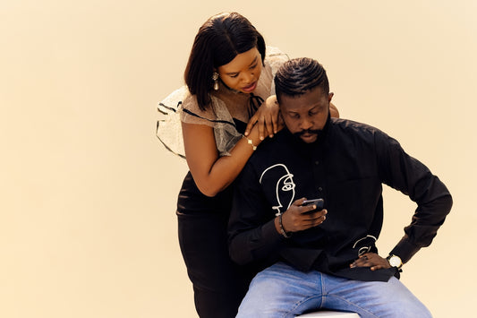A man sitting on a woman's lap with a cell phone