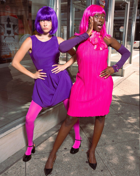 Two women in vibrant purple and pink outfits