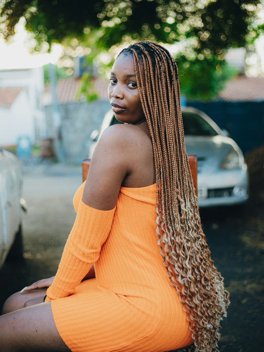 Woman with long braided hair in orange dress