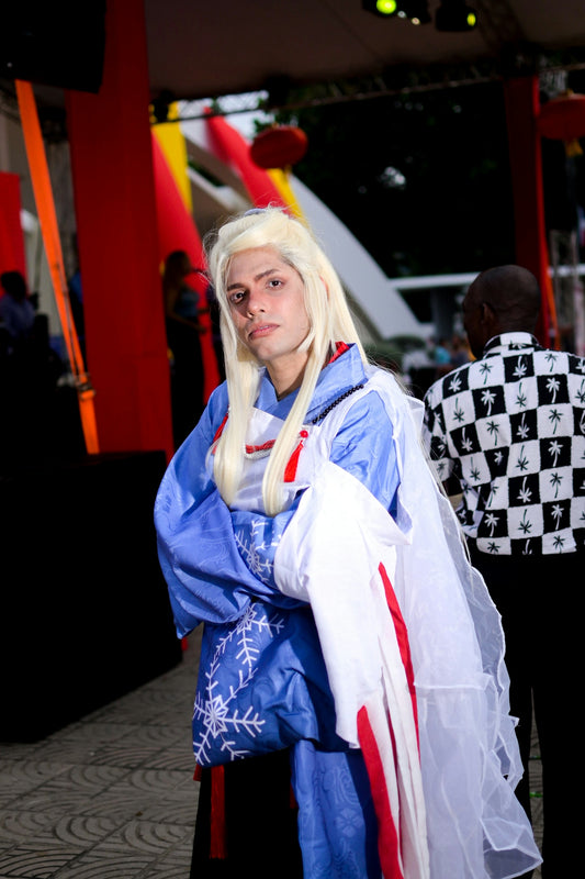 Person in blue and white costume with blonde wig.